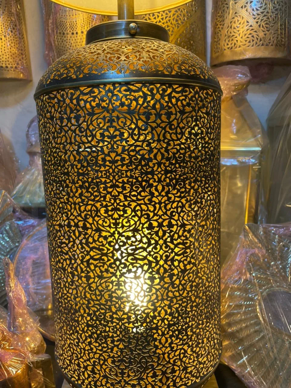 Light shining through the floral cutwork of a brass lantern